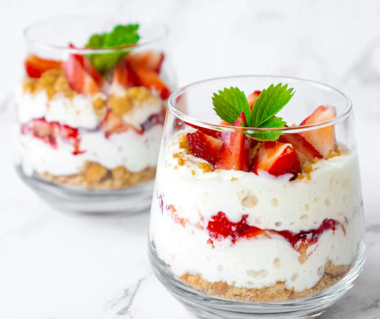 Two bowls of Strawberry Protein Cheesecake with strawberries and mint sprigs.