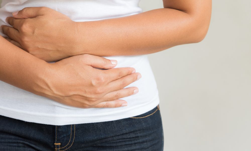 Woman cradles her upset stomach tummy 