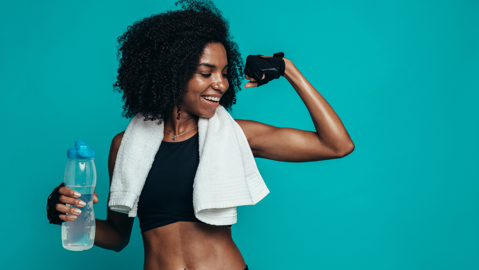 Athletic Black woman with a bottle of water making a muscle
