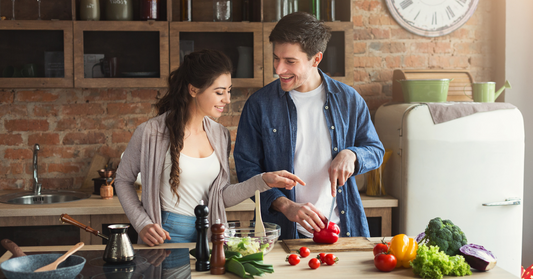 Couple cooking healthy food in their home kitchen.