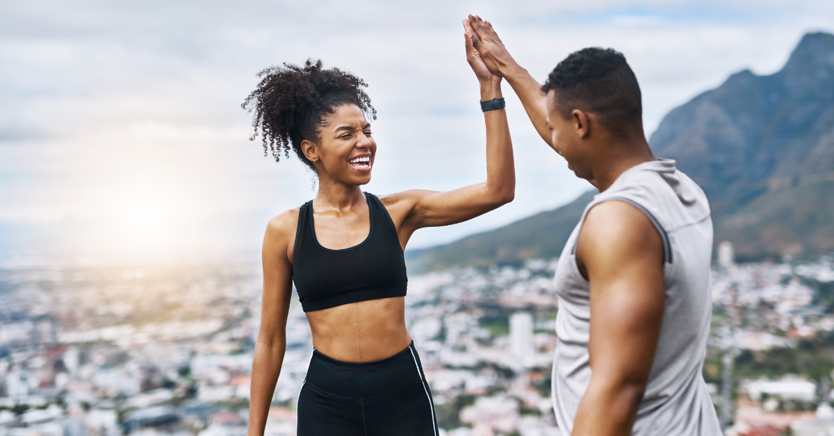 A very athletic man and an athletic woman give a high five