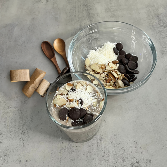 Two glass bowls of Almond Joy Overnight Chia Pudding with shaved almonds and chocolate chips.