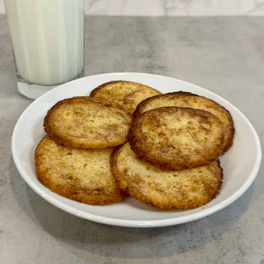 Plate full of Protein Snickerdoodle Cookies on a plate with a class of milk.