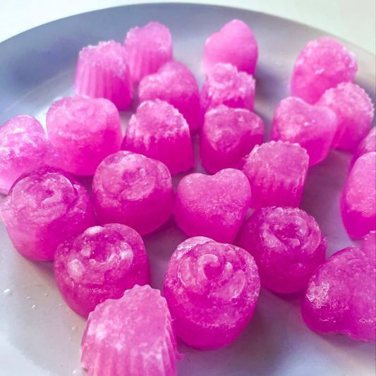 Bright pink heart shaped Keto Gummies on a plate. 